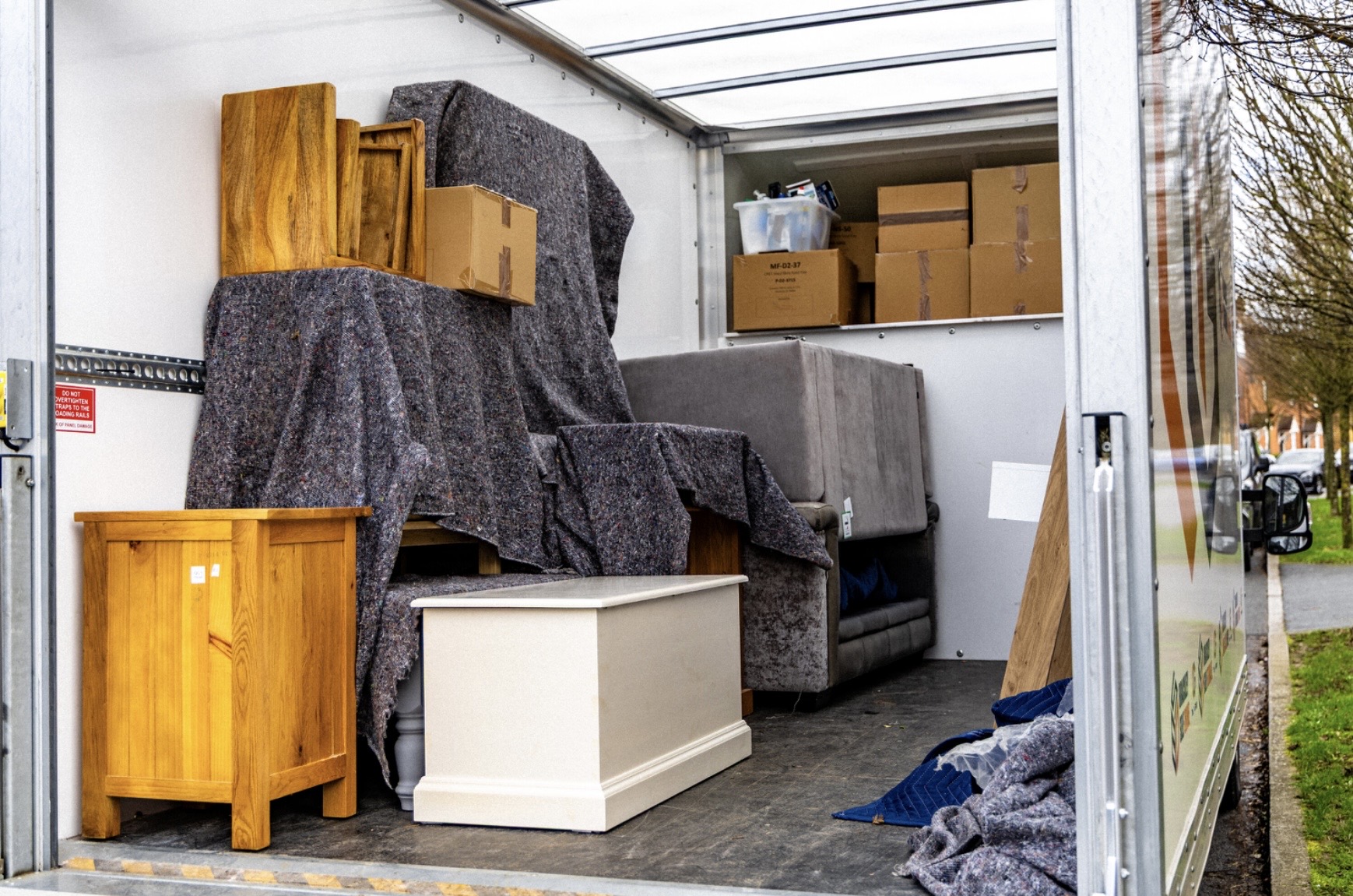 Furniture wrapped in protective blankets inside a removal van